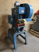 A used Kenco Teledyne 10 Ton Taber Press, model number 101-095-150, with blue and red colors, showing signs of wear and sticker residue.